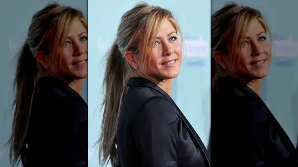 Jennifer Aniston looking over her shoulder while wearing her hair in a ponytail with side-swept bangs