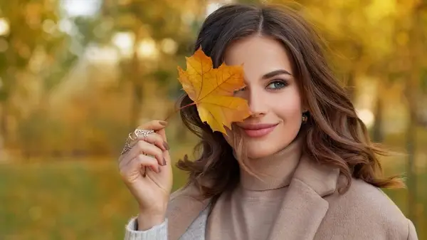 woman covering eye with leaf