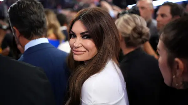Kimberly Guilfoyle at an event, turning around and smiling at the cameras