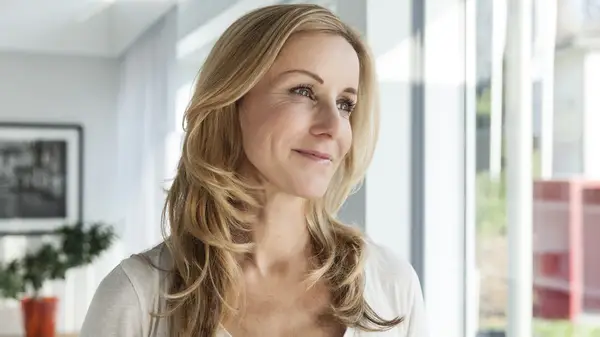 A mature woman with blonde hair and layers