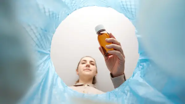 Woman throwing product into garbage