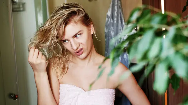 A woman inspecting her hair