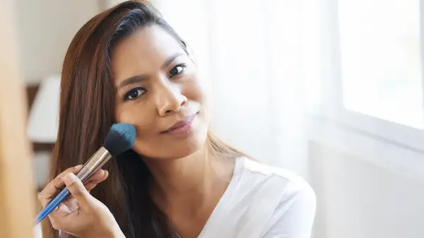 Woman applying translucent powder