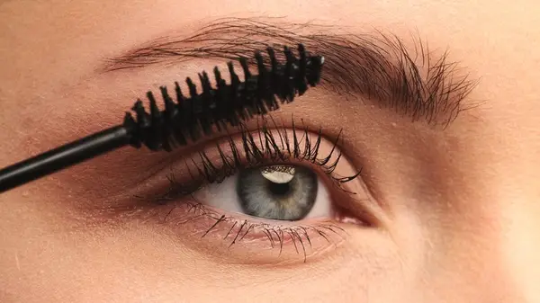 woman applies mascara