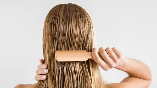 Woman brushing wet hair 
