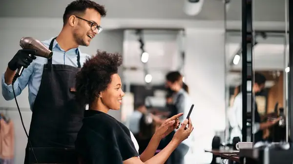 Woman showing hairdresser a photo