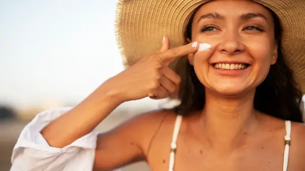 A woman applying SPF on her face