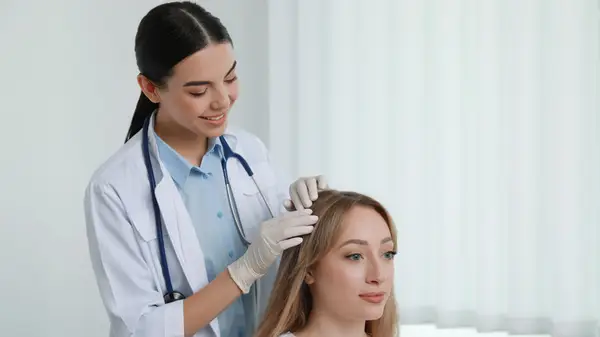 A trichologist examines a patient