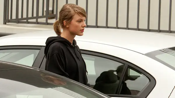 Taylor Swift wearing a ponytail and no makeup while being photographed by papparazzi in LA