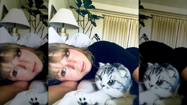 Taylor Swift laying on her side while pising with her cat
