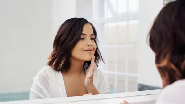 woman with lob looking in mirror