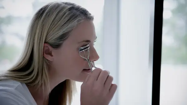 Woman using an eyelash curler