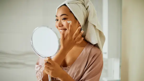 woman moisturizing face