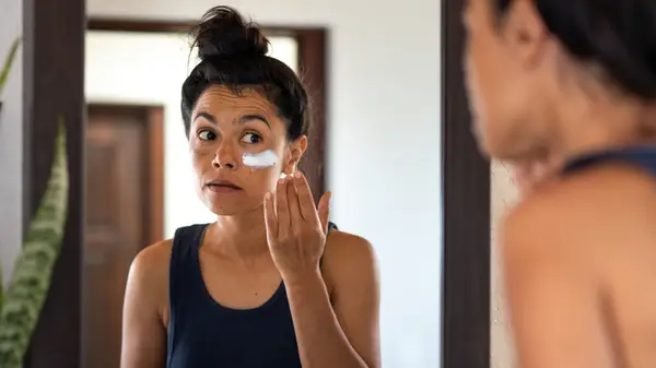 Woman applying sunscreen to her face
