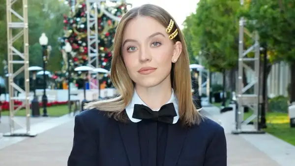 Sydney Sweeny smiling with darker hair