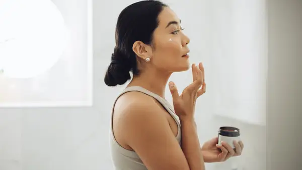 Woman applying moisturizer
