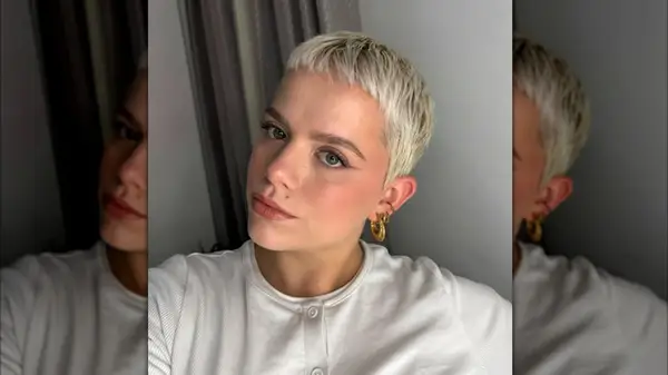 A blonde woman on Instagram with a pixie cut and gold earrings