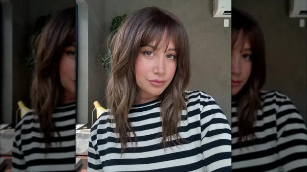 A woman with a longer shag wearing a striped shirt