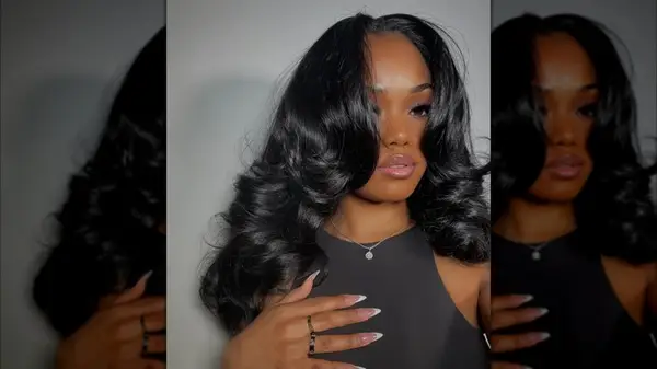 A woman with thick, wavy hair and curtain bangs