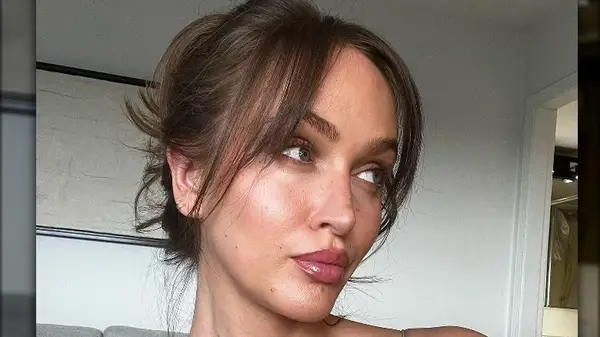 A brunette woman with a bun and bangs