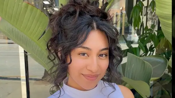 A woman with curly hair in a bun 