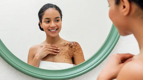 Woman applying coffee scrub