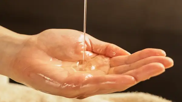 Woman pouring body oil 