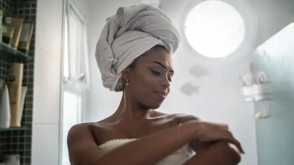 Woman moisturizing her shoulder 