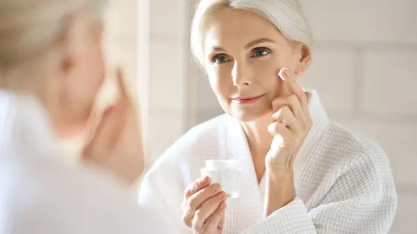 Woman applying moisturizer
