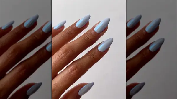 A hand with pastel blue nails with a chrome finish