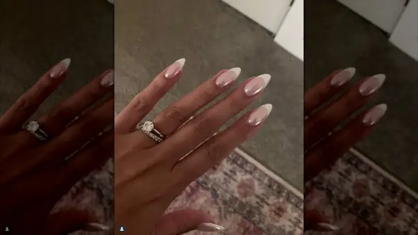 A hand with a chrome-finish French manicure