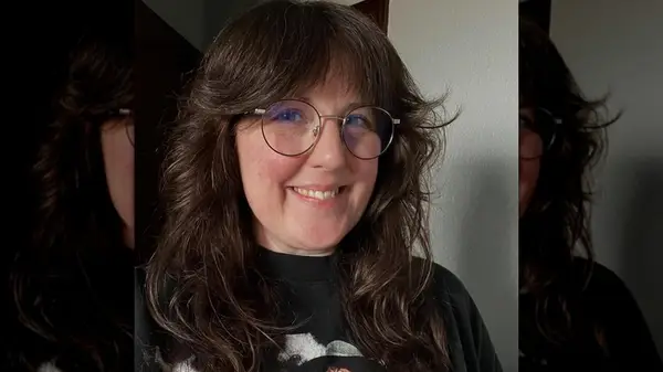 Woman with curtain bangs and round glasses