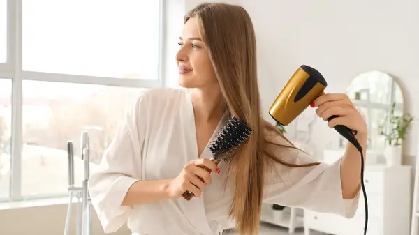 Woman blow drying her hair