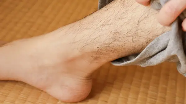 Hairy leg on a woven mat