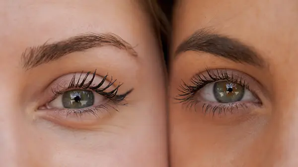 Close-up of two women with green eyes with long lashes cheek to cheek
