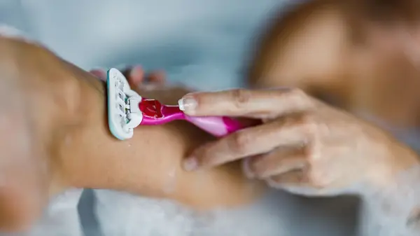 Woman shaving her legs