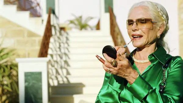 model applying lipgloss in mirror