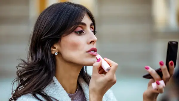 Woman applying lipstick