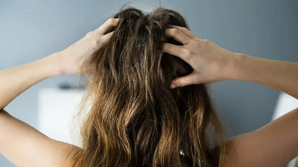 Woman running hands through damaged hair