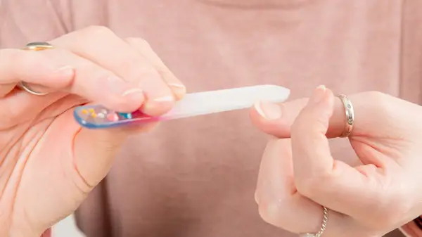 woman using glass nail file 