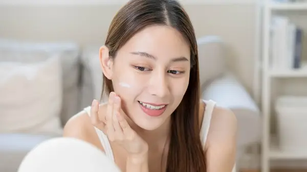 Woman applying moisturizer