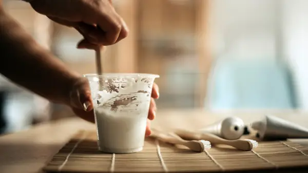 person stirring baking soda in cup