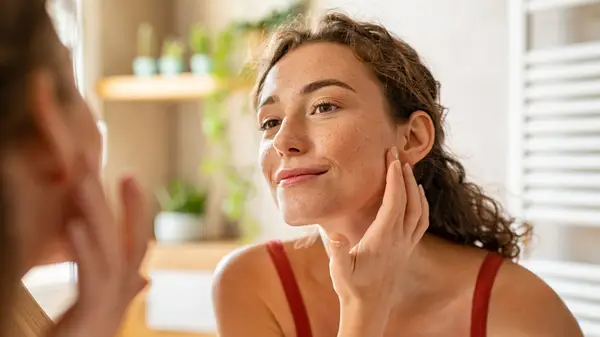 Woman applying lotion to face