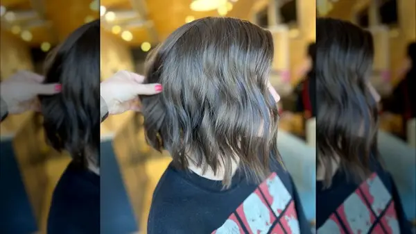 A side shot of a brunette woman with a bob haircut that