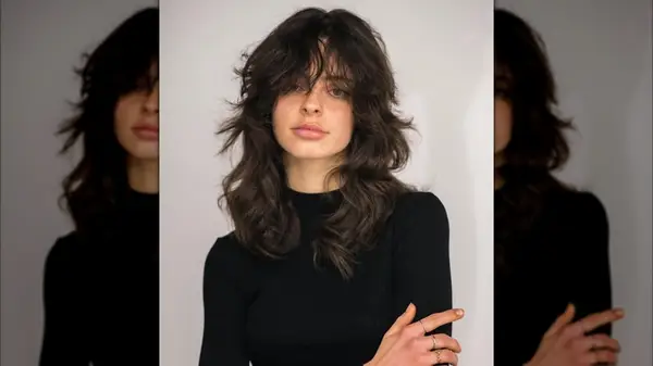 A woman with dark hair cut into a heavily layered shag