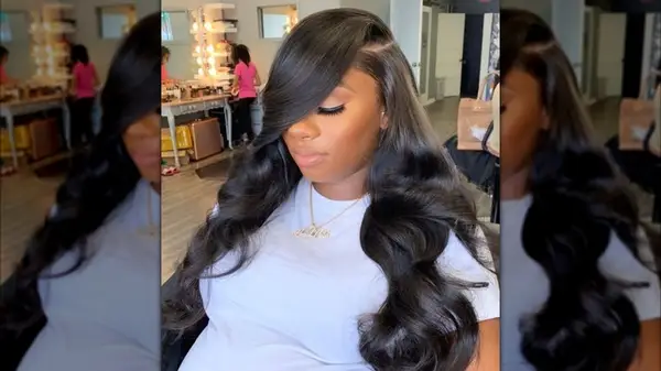 A woman with dark hair that has a deep side part and large curls