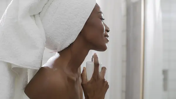 Woman applying perfume 