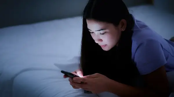 Woman on phone in bed