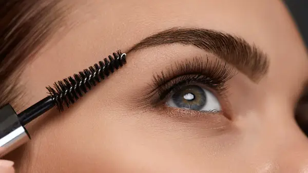 Woman applying eyebrow gel
