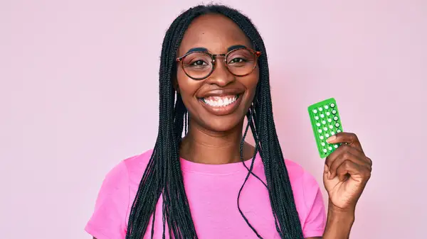 Woman holding a package of birth control pills
